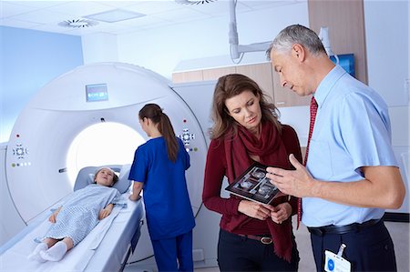 Doctor and mother looking at scan, girl going into CT scanner Stockbilder - Premium RF Lizenzfrei, Bildnummer: 649-07709922