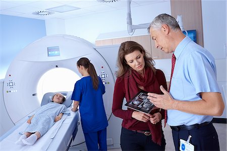 Doctor and mother looking at scan, girl going into CT scanner Photographie de stock - Premium Libres de Droits, Code: 649-07709922