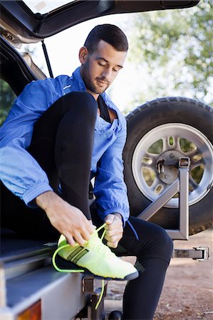 Male jogger tying shoelace at back of car Foto de stock - Sin royalties Premium, Código: 649-07709997