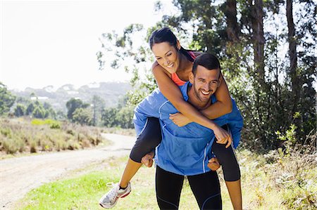 Female jogger riding piggyback on man Stock Photo - Premium Royalty-Free, Code: 649-07710005