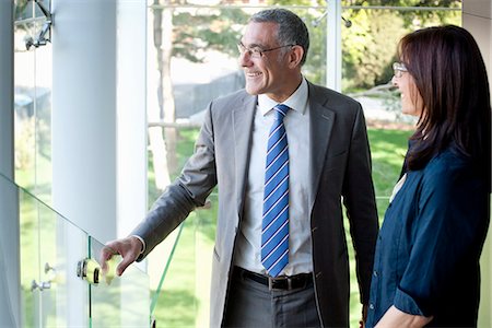 standing on trust - Businessman and woman looking out of office building Stock Photo - Premium Royalty-Free, Code: 649-07710036