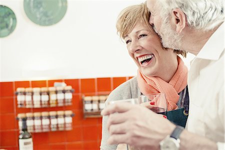 Senior man kissing woman in kitchen, woman laughing Stock Photo - Premium Royalty-Free, Code: 649-07710412