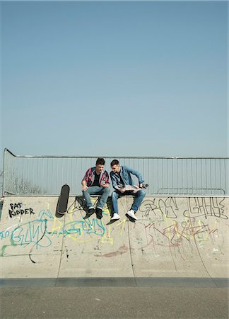 denim shirt - Young men in skatepark, using smartphone Stock Photo - Premium Royalty-Free, Code: 649-07710450