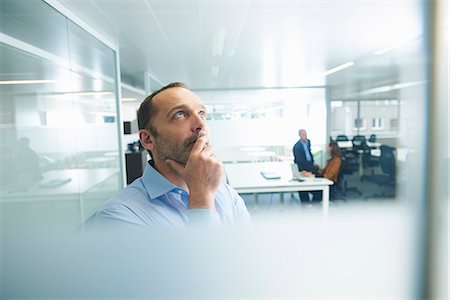 reflecting - Man thinking, people in background Stock Photo - Premium Royalty-Free, Code: 649-07710477