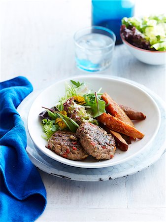 simsearch:649-07710550,k - Still life of turkey patties with sweet potato and mesclun salad Stock Photo - Premium Royalty-Free, Code: 649-07710549