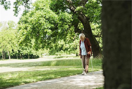 Senior woman walking through park, using walking stick Stock Photo - Premium Royalty-Free, Code: 649-07710578