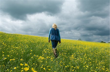 simsearch:649-07063059,k - Woman walking in field of buttercups Stock Photo - Premium Royalty-Free, Code: 649-07710583