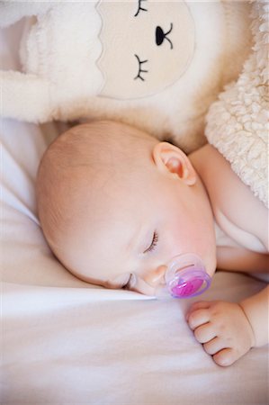 dummy (pacifier) - Baby girl sleeping in crib with cuddly toy Foto de stock - Sin royalties Premium, Código: 649-07710655