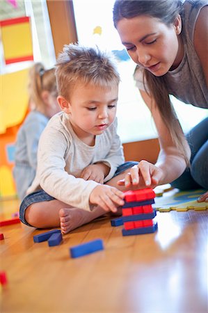 Teacher and boy constructing building blocks at nursery school Foto de stock - Sin royalties Premium, Código: 649-07710802