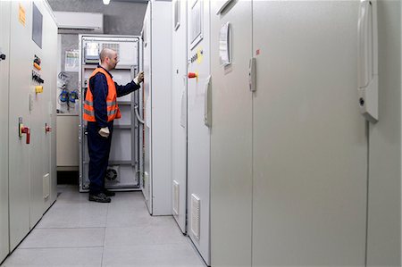 sala de controle - Technician doing a check in power station control room Foto de stock - Royalty Free Premium, Número: 649-07710831