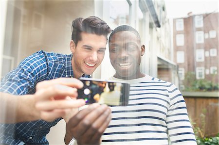 roommate (male) - Two young male friends taking selfie behind patio glass Stock Photo - Premium Royalty-Free, Code: 649-07736424
