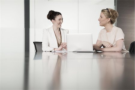 Two young businesswomen having face to face meeting in conference room Photographie de stock - Premium Libres de Droits, Code: 649-07736436