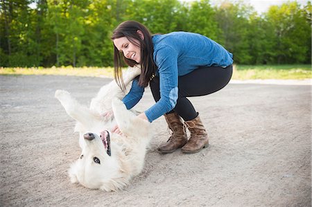 pets people - Young woman petting golden retriever on roadside Stock Photo - Premium Royalty-Free, Code: 649-07736483