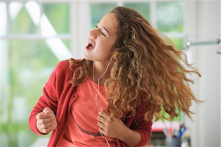 Young girl wearing headphones, dancing to music Stock Photo - Premium Royalty-Free, Code: 649-07736661