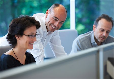 Colleagues sitting at desk, smiling Photographie de stock - Premium Libres de Droits, Code: 649-07736681