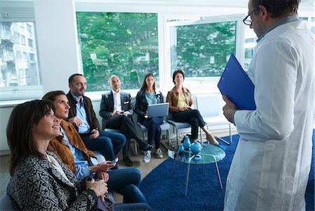 simsearch:649-07736690,k - Group of people sitting, looking at man in labcoat Stock Photo - Premium Royalty-Free, Code: 649-07736696