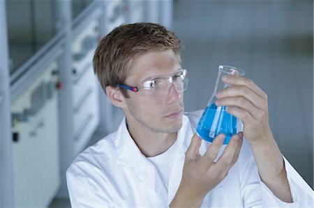 simsearch:649-07118833,k - Male scientist holding up erlenmeyer flask in lab Foto de stock - Sin royalties Premium, Código: 649-07736707