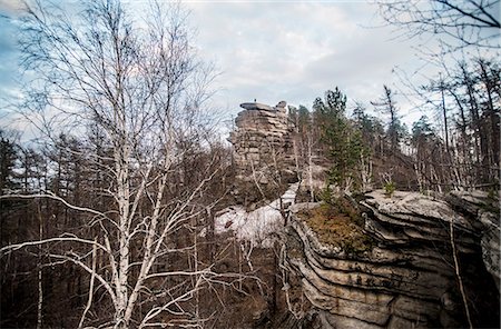 simsearch:649-07710646,k - Climber on top of rock formation in mountain forest Foto de stock - Royalty Free Premium, Número: 649-07736814