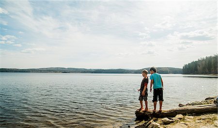 simsearch:649-07804678,k - Two boys standing on fallen tree looking down into lake Stock Photo - Premium Royalty-Free, Code: 649-07736824