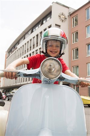 simsearch:649-07736779,k - Portrait of ten year old boy pretending to ride motor scooter on city street Stock Photo - Premium Royalty-Free, Code: 649-07736897