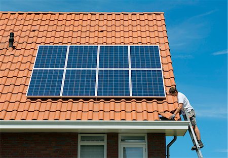 renewable energy - Worker checking installation of solar panels on roof of new home, Netherlands Stock Photo - Premium Royalty-Free, Code: 649-07736928