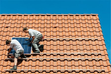 energy (power source) - Workers installing solar panel on roof framework of new home, Netherlands Stock Photo - Premium Royalty-Free, Code: 649-07736921