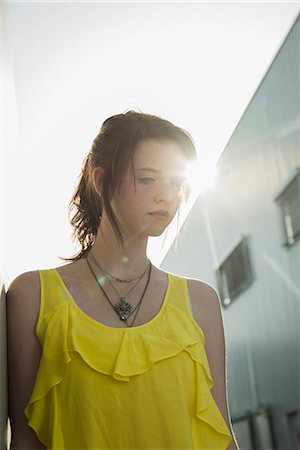 simsearch:695-05774213,k - Young sullen girl in yellow blouse gazing down Stock Photo - Premium Royalty-Free, Code: 649-07736949