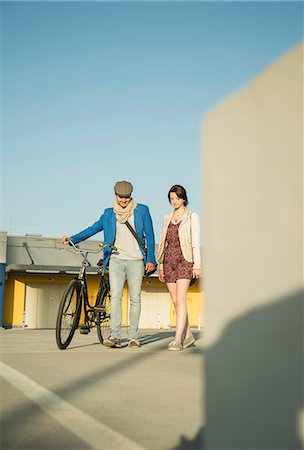 Young couple pushing bicycle along street Stock Photo - Premium Royalty-Free, Code: 649-07736964