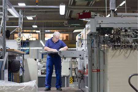 Worker using machine in paper packaging factory Photographie de stock - Premium Libres de Droits, Code: 649-07736992