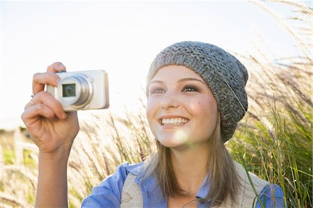 Young woman taking photograph with camera in fields Stock Photo - Premium Royalty-Free, Code: 649-07737004