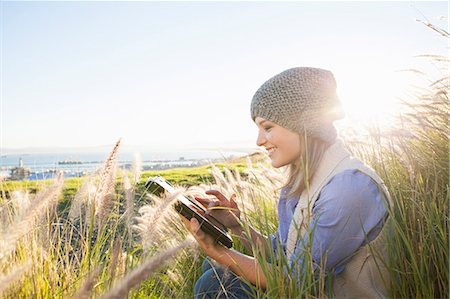 photo joyful - Young woman using digital tablet in fields Stock Photo - Premium Royalty-Free, Code: 649-07737005