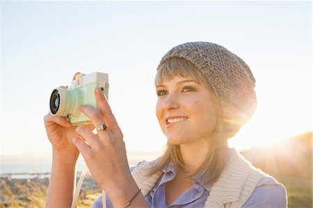 Young woman taking photograph with camera at sunset Photographie de stock - Premium Libres de Droits, Code: 649-07737011