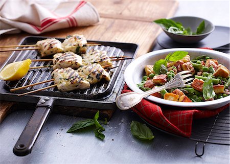 Chargrilled snapper skewers with lemon and bowl of salad Photographie de stock - Premium Libres de Droits, Code: 649-07737044