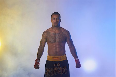 Studio portrait of muscular male boxer in spotlights and mist Photographie de stock - Premium Libres de Droits, Code: 649-07737115