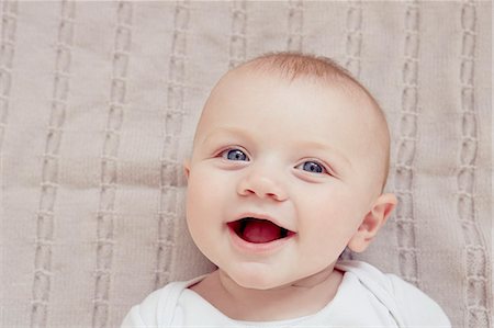 Close up portrait of smiling baby boy lying on blanket Stock Photo - Premium Royalty-Free, Code: 649-07760798