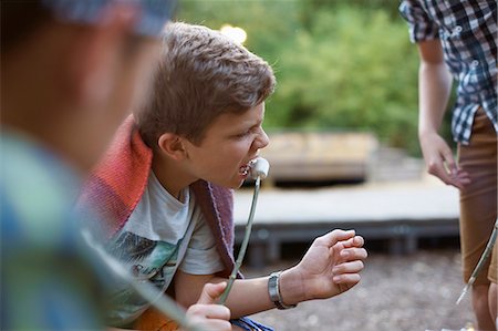 simsearch:614-06402640,k - Young boy eating toasted marshmallow from stick Foto de stock - Sin royalties Premium, Código: 649-07760870