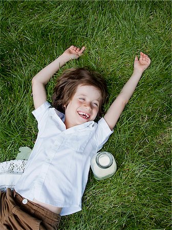 people happiness relaxed - Boy lying on grass laughing Stock Photo - Premium Royalty-Free, Code: 649-07760884