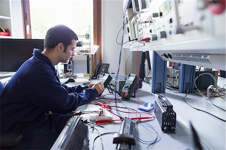 energy (power source) - Male electrician repairing electronic equipment in workshop Foto de stock - Sin royalties Premium, Código: 649-07760896