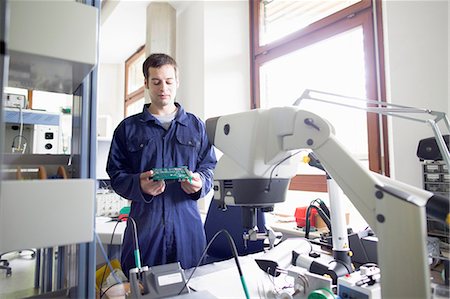 electronic device - Male electrician looking down at circuit board in workshop Stock Photo - Premium Royalty-Free, Code: 649-07760893