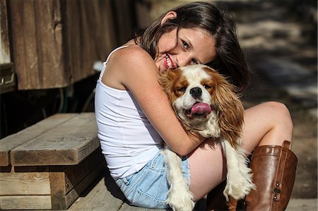 Portrait of smiling girl hugging dog on steps Foto de stock - Sin royalties Premium, Código: 649-07760934
