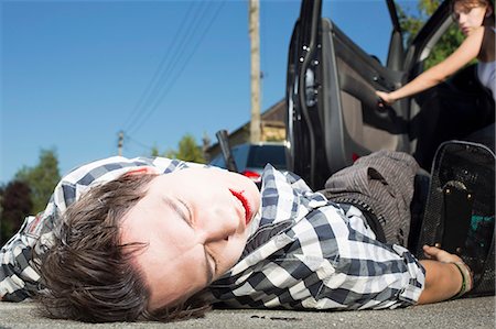 Young man hit by car lying on road Photographie de stock - Premium Libres de Droits, Code: 649-07761002