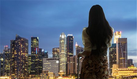 person thinking uncertain - Young woman with suitcase looking at city skyline Stock Photo - Premium Royalty-Free, Code: 649-07761010