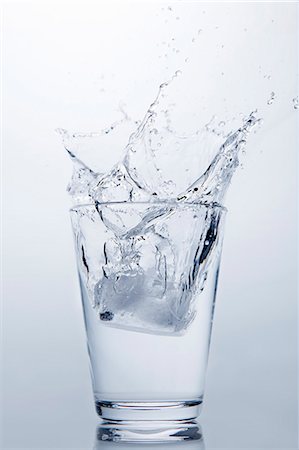 simsearch:614-06624533,k - Ice cube splashing into glass of clear water Foto de stock - Sin royalties Premium, Código: 649-07761094