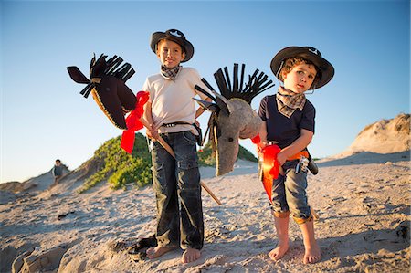 Two brothers dressed as cowboy's with hobby horse's Stock Photo - Premium Royalty-Free, Code: 649-07761109