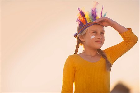 ficción - Girl dressed as native american in feather headdress with hand shading eyes Foto de stock - Sin royalties Premium, Código: 649-07761116