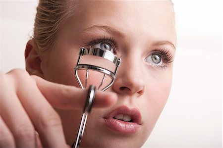 rizador de pestañas - Teenage girl using eyelash curlers Foto de stock - Sin royalties Premium, Código: 649-07761138