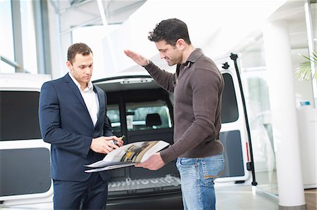 spacious - Customer questioning salesman in car dealership Foto de stock - Sin royalties Premium, Código: 649-07761164