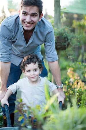 parent teaching outdoor - Portrait of  mid adult man and son pushing wheelbarrow in allotment Stock Photo - Premium Royalty-Free, Code: 649-07761191