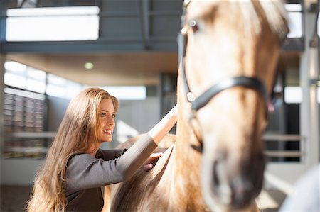 Young female stablehand grooming palomino horse Stock Photo - Premium Royalty-Free, Code: 649-07761206