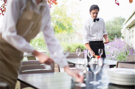 Waitress preparing wine glasses on table in patio restaurant Foto de stock - Sin royalties Premium, Código: 649-07761230